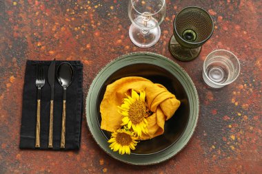 Trendy table setting with beautiful sunflowers on color background