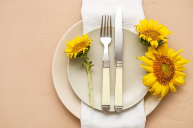 Simple table setting with sunflowers on beige background