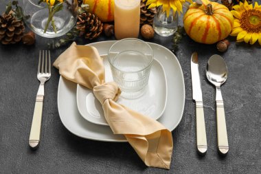 Beautiful dinnerware and autumn decor on dark table