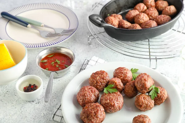 Plate with tasty meat balls, parsley and sauce on grunge background, closeup
