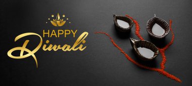 Greeting card for Indian holiday Diwali (Festival of lights) with diya lamps on dark background