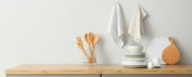 Interior of stylish kitchen with utensils and dinnerware on counter