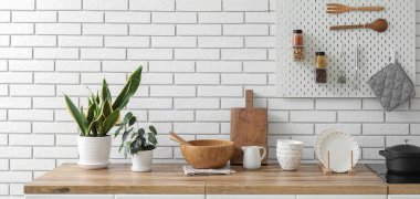 Interior of stylish kitchen with houseplants, utensils and pegboard