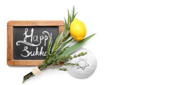 Sukkot festival symbols and chalkboard on white background with space for text