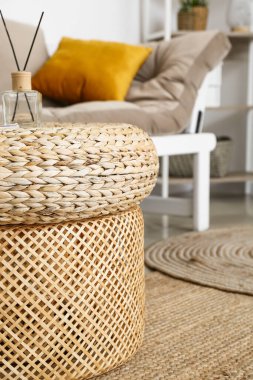 Rattan poufs with reed diffuser in living room, closeup
