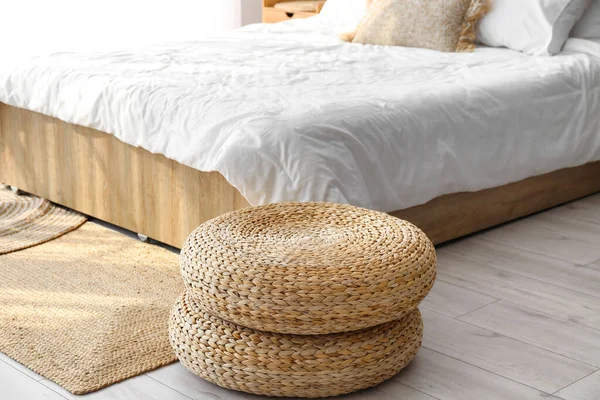 Rattan poufs and carpet in bedroom