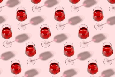 Many glasses of red wine on pink background. Pattern for design