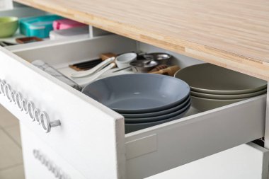 Open drawer with utensils in kitchen, closeup
