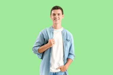 Teenage boy with backpack on green background