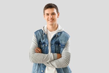 Teenage boy in denim jacket on light background