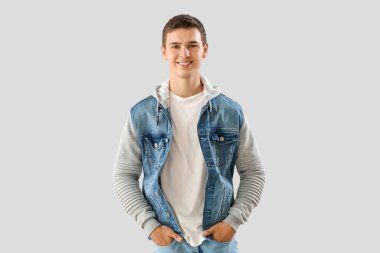 Teenage boy in denim jacket on light background