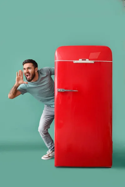 Screaming Tattooed Young Man Red Fridge Green Background — Stock Photo, Image