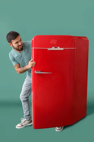 Cool Tattooed Young Man Getting Out Red Fridge Green Background — Stock Photo, Image
