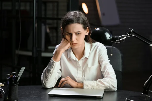 Tired businesswoman sitting in office at night