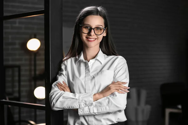 Smiling businesswoman in office at night