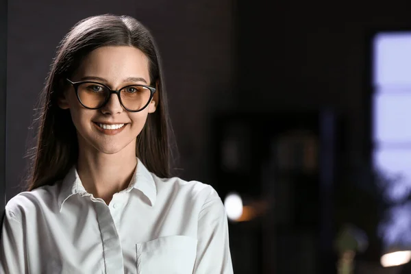 Smiling businesswoman in office at night