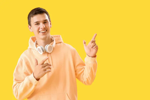 Teenage Boy Headphones Pointing Something Yellow Background — Stock Photo, Image