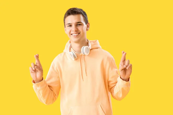 Teenage Boy Headphones Crossing Fingers Yellow Background — Stock Photo, Image