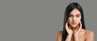 Young woman with beautiful black straight hair on grey background with space for text