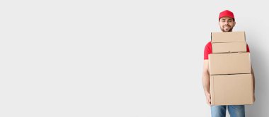 Delivery man with boxes on light background with space for text