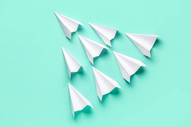 Renkli arka planda beyaz kağıt uçaklar