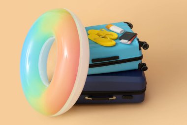 Suitcases with flip-flops, bottle of sunscreen, passports and inflatable ring on color background