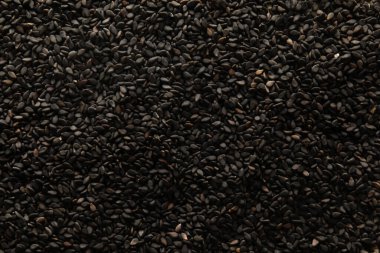 Black sesame seeds as background, closeup