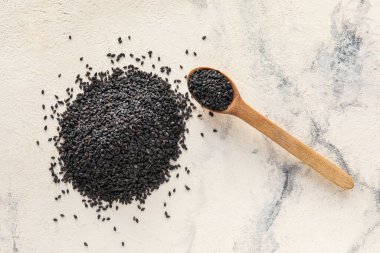 Heap of black sesame seeds on light background