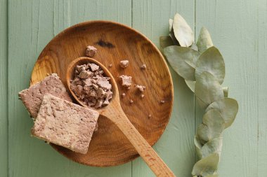 Plate with tasty sesame halva on color wooden background