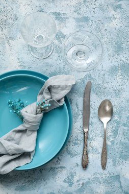 Beautiful table setting and gypsophila flowers on blue background