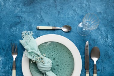Table setting decorated with gypsophila flowers on blue background