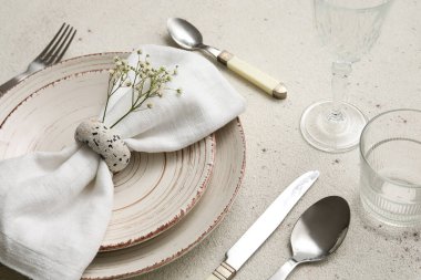 Dinnerware with beautiful gypsophila flowers on light table