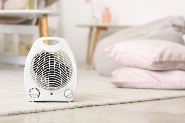 Electric fan heater on carpet in living room