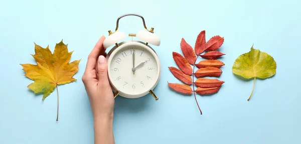 Female Hand Alarm Clock Autumn Leaves Light Blue Background — Foto de Stock