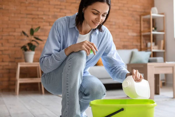 Young Housewife Pouring Detergent Bucket Home — Stockfoto