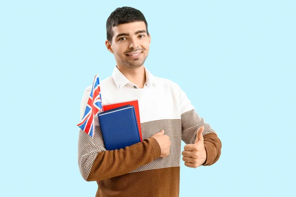 Young Man Flag Books Showing Thumb Blue Background — Zdjęcie stockowe