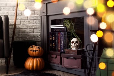 Decorative fireplace with books and Halloween decor in living room