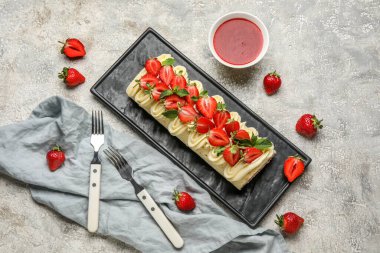 Composition with tasty strawberry roll cake and jam on grunge background
