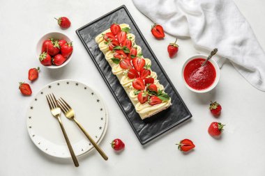 Composition with tasty strawberry roll cake, jam and berries on light background