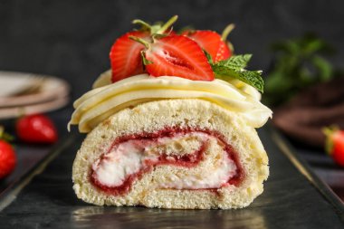 Board with tasty strawberry roll cake, closeup