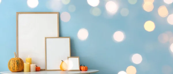 Blank Frames Autumn Pumpkins Candles Table Blue Wall — Stock Photo, Image
