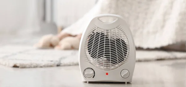 Electric fan heater on floor in room