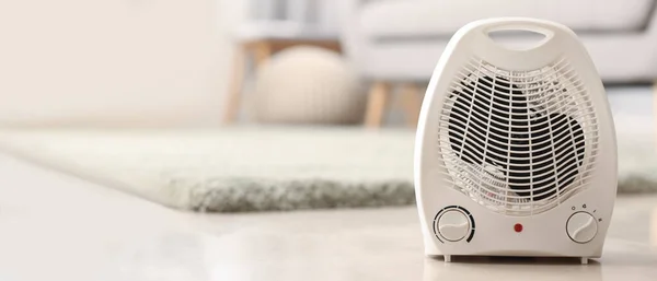 Electric fan heater on floor in room