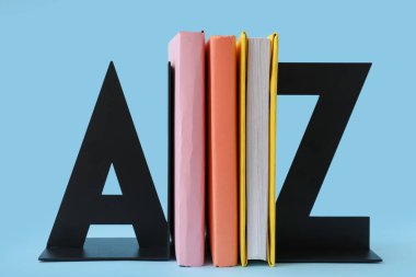 Stylish stand with books on blue background