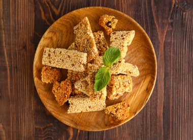 Ahşap zemin üzerinde susam tohumları olan lezzetli kozinaki parçalarıyla dolu bir tabak.