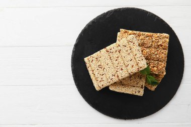 Hafif ahşap arka planda lezzetli susamlı kozinaki çubukları olan tahta.