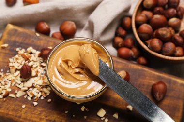 Ahşap tahta tahtada bir kase lezzetli fındık ezmesi, yakın plan.