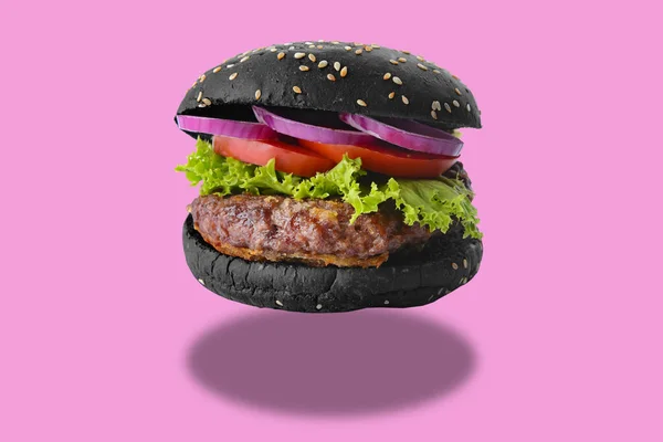 Tasty fresh burger with black bun on pink background