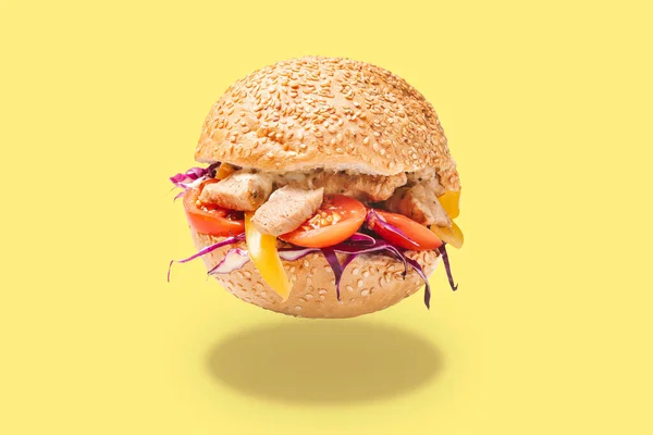 Tasty doner kebab in bun on yellow background