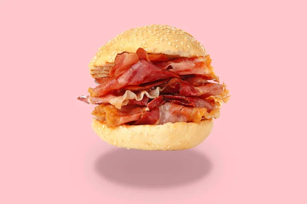 Tasty burger with bacon on pink background